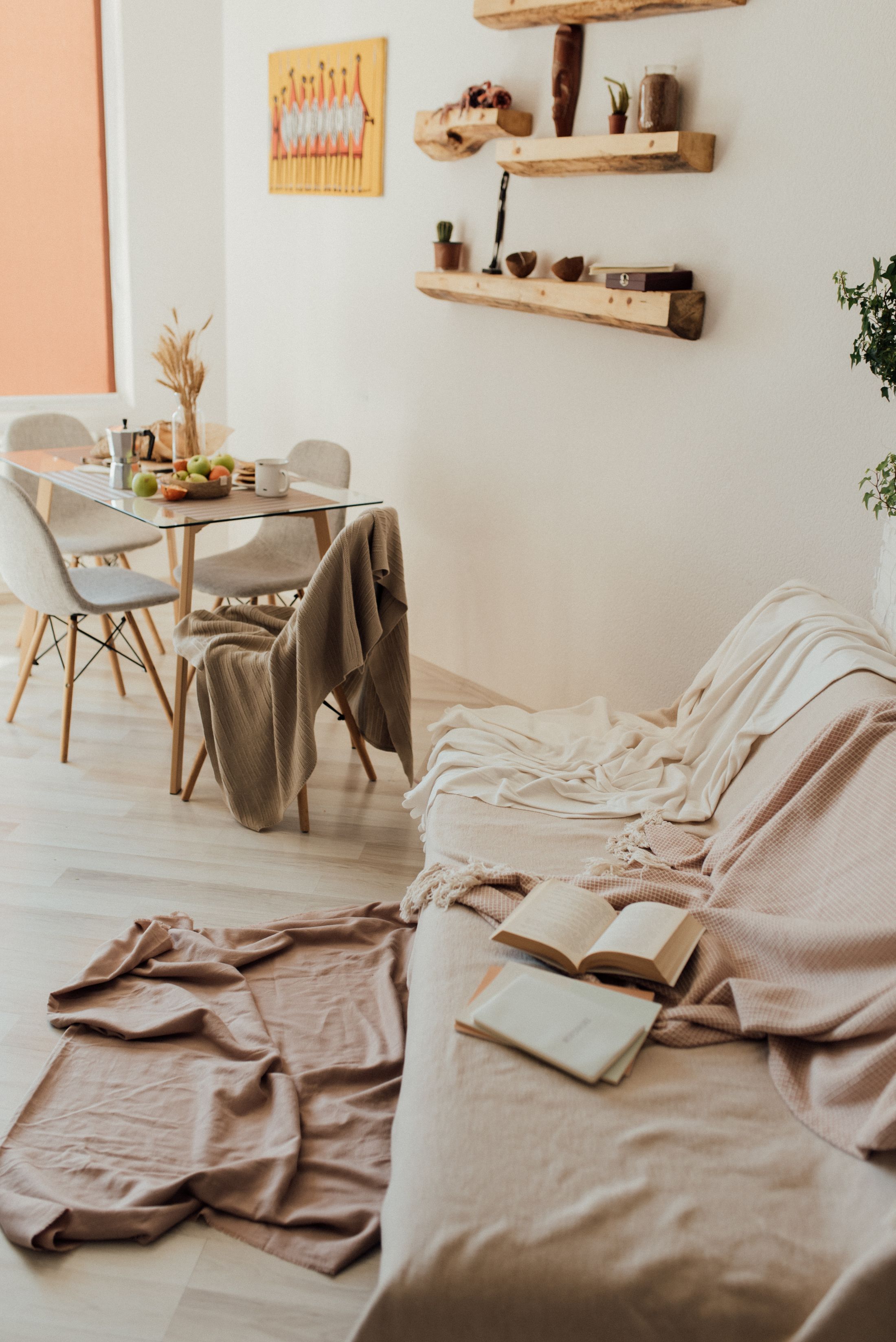 Een licht, eenvoudig ingericht appartement met een eettafel en een bank